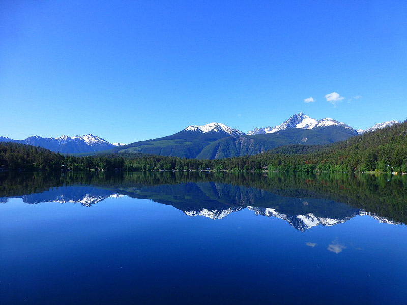 A scenic vista from Gun Lake with mountains and forest in the distance.